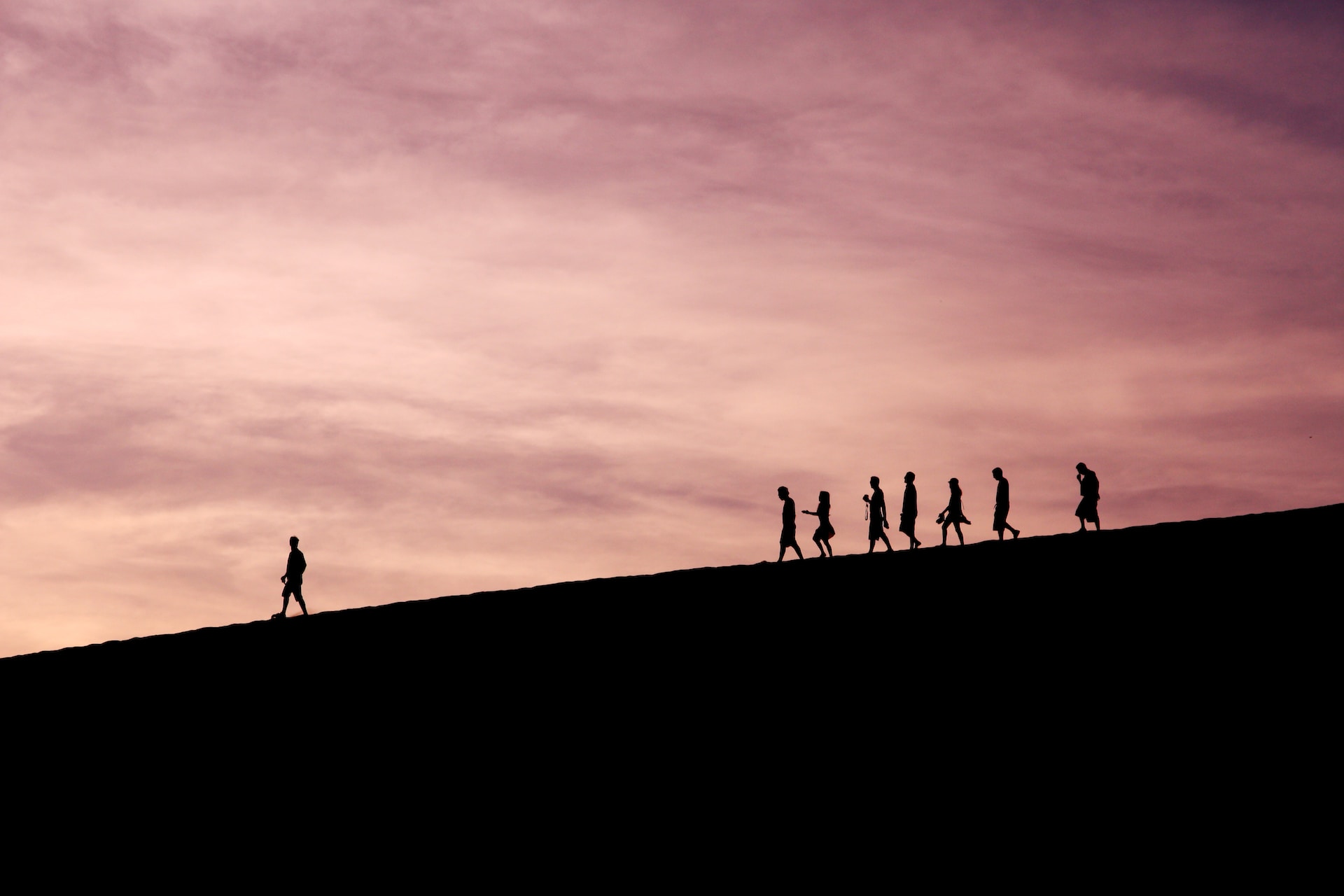 man leading group on mountain top