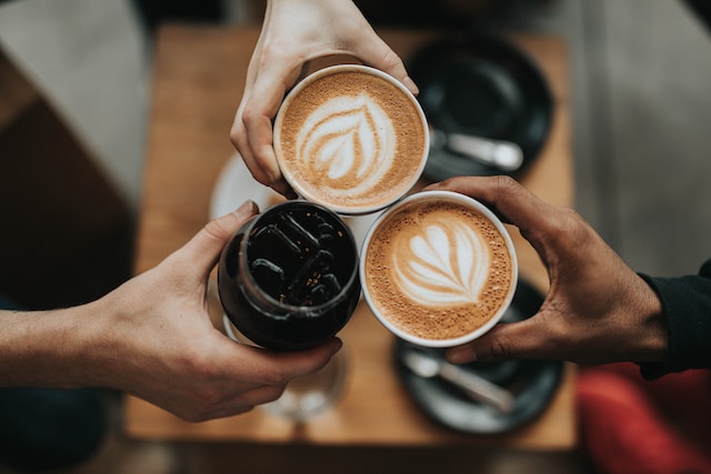 3 people cheering their coffee