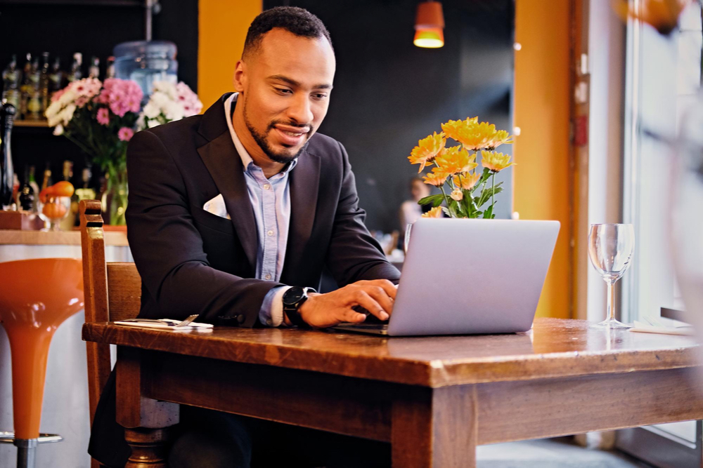 male in suit using laptop